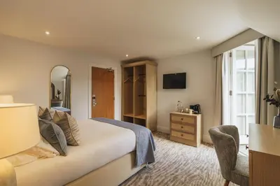 a hotel room with a bed and a mirror at The Old Quay House Hotel in Fowey