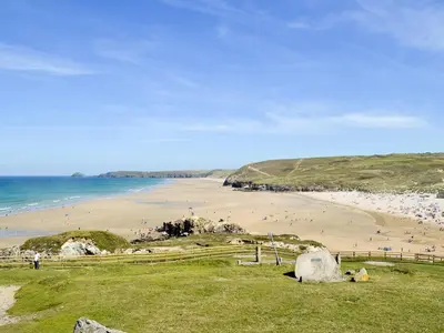 a beach with a bunch of people on the sand at Lyndhurst in Perranporth