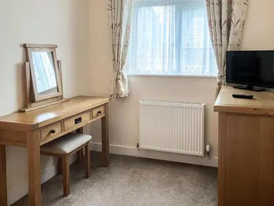 a room with a desk and a mirror and a window at Knights Den in Port Isaac