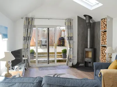 a living room with a blue couch and a fireplace at Little Tregarthen in Padstow