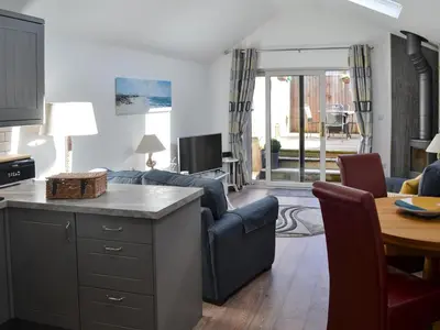 a living room with a couch and a table at Little Tregarthen in Padstow