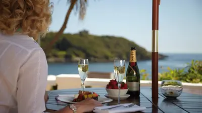 a woman sitting at a table with glasses of wine at The Royal Duchy Hotel in Falmouth