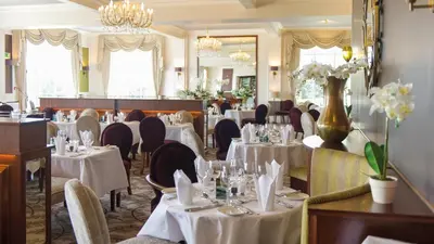 a dining room with tables and chairs with white tablecloths at The Royal Duchy Hotel in Falmouth