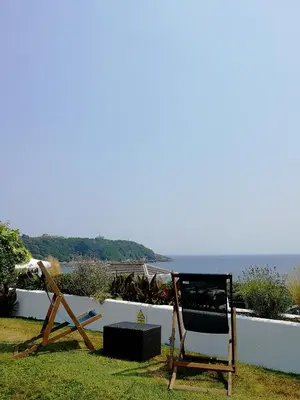 a chair sitting on the grass next to the ocean at The Royal Duchy Hotel in Falmouth