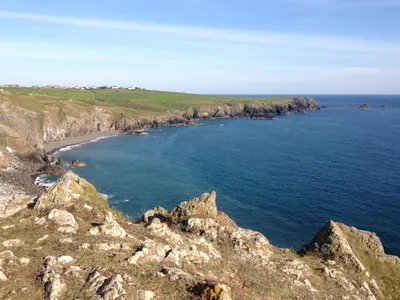 a view of the ocean and a rocky coast at Enys Boathouse in Porkellis