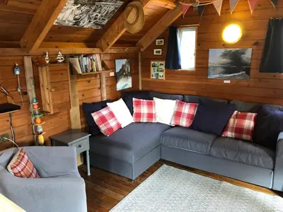 a living room with a couch in a cabin at Enys Boathouse in Porkellis