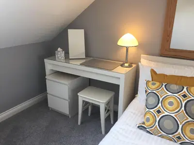 a bedroom with a desk with a chair and a bed at Rosenn Teyr in St. Agnes