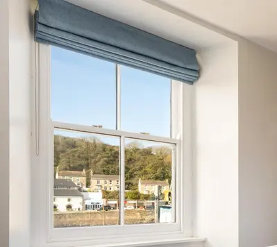 a window with a blue curtain in a room at Harbour Inn in Porthleven