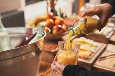 a person pouring a drink into a glass on a counter at Harbour Inn in Porthleven