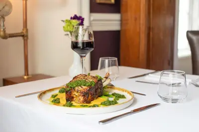 a plate of food on a table with a glass of wine at Penventon Park Hotel in Redruth