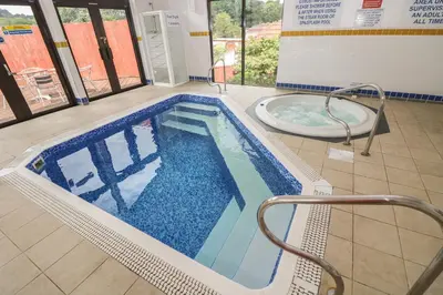 a large swimming pool with a tub in a building at Bramble Cottage in Falmouth
