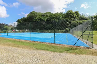 a tennis court with a net on top of it at Bramble Cottage in Falmouth