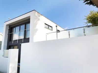 a white fence in front of a white house at An Drowes in Newquay
