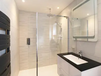 a bathroom with a glass shower and a sink at An Drowes in Newquay
