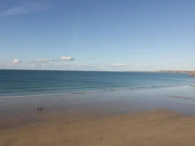 a group of people walking on the beach at Buena Vista in Newquay