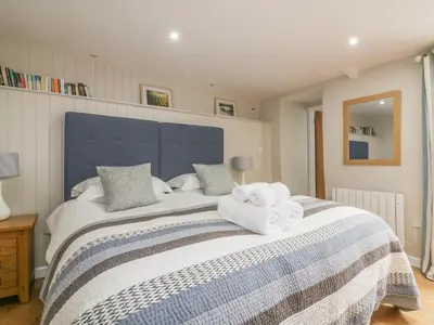 a bedroom with a large bed with towels on it at The Bolthole in Crantock