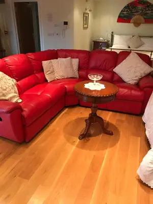 a red couch in a living room with a table at Orchard Manor in Probus