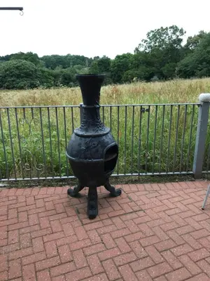 a black vase sitting on top of a brick sidewalk at Orchard Manor in Probus