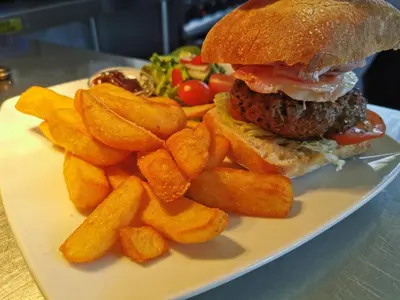 a white plate with a hamburger and french fries at Sportsmans Valley Hotel in Liskeard