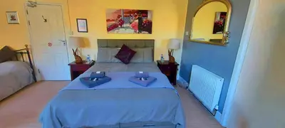 a bedroom with a blue bed with two pillows on it at Sportsmans Valley Hotel in Liskeard