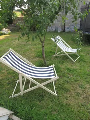 two lawn chairs sitting in the grass next to a tree at Treganoon House, Lanlivery in Bodmin