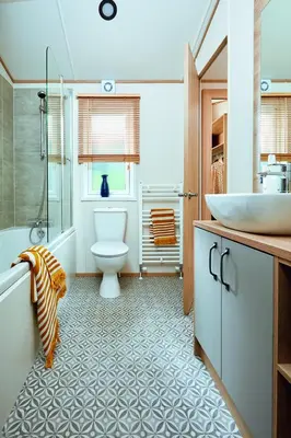 a bathroom with a sink and a toilet and a tub at Newperran Holiday Resort in Newquay