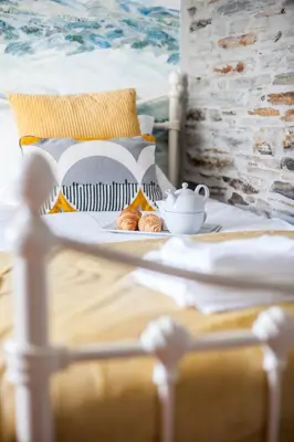 a table with a tea set on a bed at The Olde Malthouse Inn in Tintagel