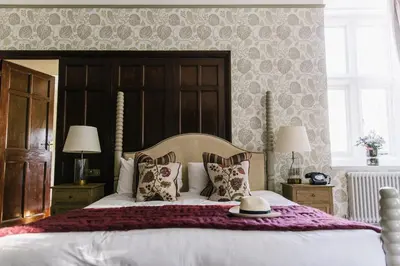 a bedroom with a large bed with a wooden headboard at The Alverton in Truro