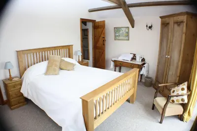 a bedroom with a bed and a desk and a chair at Lower Tresmorn Farmhouse in Crackington Haven