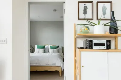 a bedroom with a bed and a shelf with a microwave at The Old Post Office Apartment in Falmouth