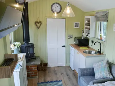 a kitchen with a sink and a clock on the wall at The Wool Shed in Saint Ewe