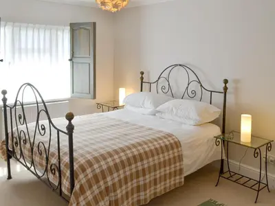 a bedroom with a bed and two tables with lamps at Trelawny Court in Saint Minver