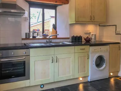a kitchen with a sink and a washing machine at THE OLD RECTORY ROSE COTTAGE in Jacobstow 10 mins to Widemouth bay and Crackington Haven,Nearby Bude,Tintagel,Port Issac,Clovelly,PARKING FOR LARGE AND MULTIPLE VEHICLES in Jacobstow