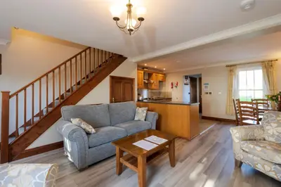 a living room with a couch and a table at Green Acres Cottages in Par
