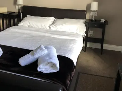 a bed with two folded towels sitting on it at The Cornubia Inn in Hayle