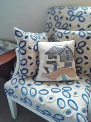 a couch with a pillow sitting on top of it at The House on the Props in Polperro