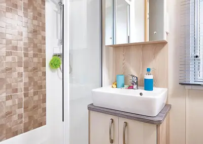 a bathroom with a sink and a shower at Trevornick Holiday Park in Holywell Bay