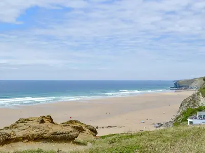 a beach with people on the sand and the ocean at Eagle Owl Lodge-Ukc3770 in Saint Columb Major