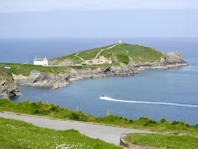 a boat in a body of water with a house at Towan View in Newquay