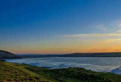 a view of a body of water at sunset at Palm Trees in Polzeath