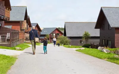 a man and a child walking down a street at Retallack Resort by Away Resorts in Padstow