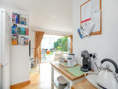 a kitchen with a table and a refrigerator at Candles Cottage in Cubert
