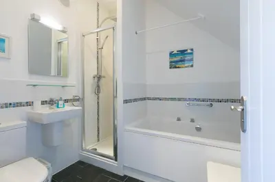 a bathroom with a tub and a toilet and a sink at Sea Crest in St Ives