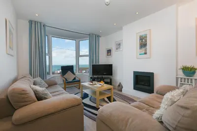 a living room with two couches and a television at Sea Crest in St Ives