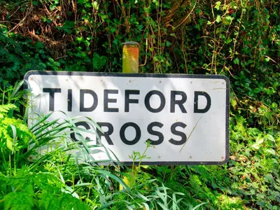 a sign for a hidden cross in the grass at Cawsand in Saltash
