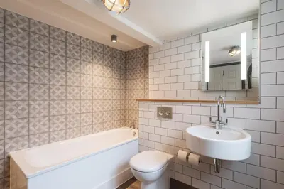 a bathroom with a sink and a toilet and a bath tub at Lifeboat Inn in St Ives