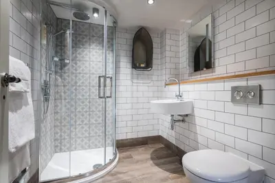 a bathroom with a shower and a toilet and a sink at Lifeboat Inn in St Ives