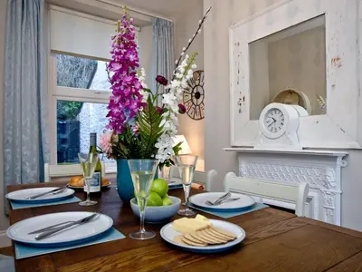 a dining room table with a vase of flowers at Kerensa in Looe