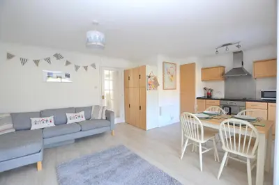 a living room with a couch and a table at Beach View Apartments in Porthtowan