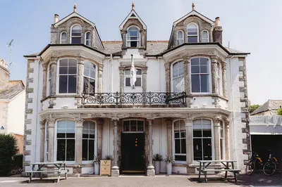 a large house with two benches in front of it at Hotel VARA in Truro